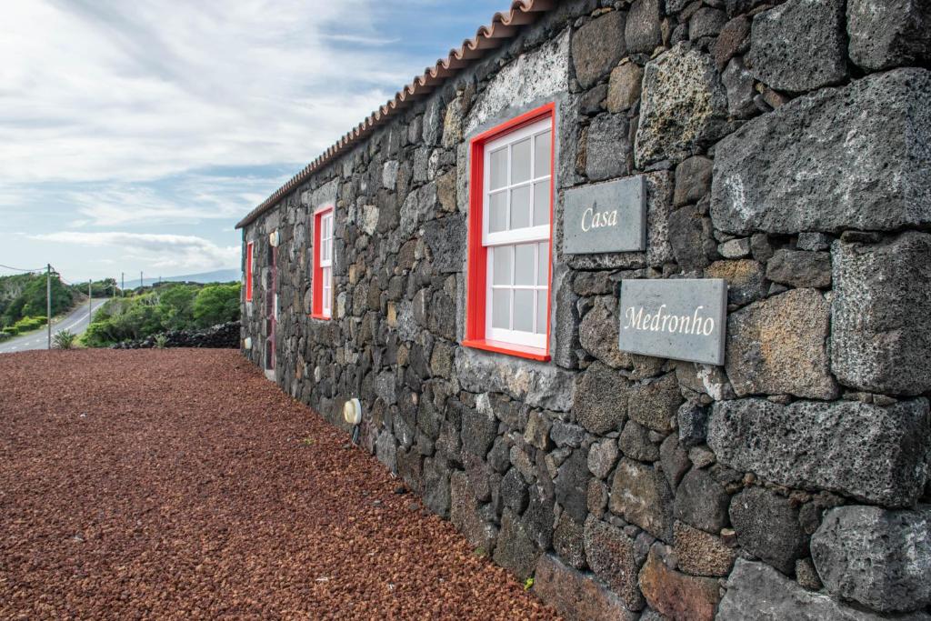 São MateusCasa Medronho的一面石墙,上面有窗户和标志