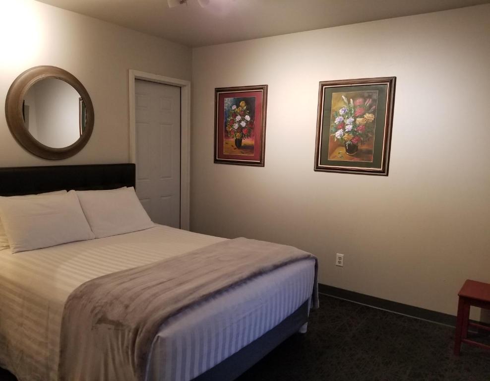 奇兰深水宾馆的卧室配有一张床,墙上挂有两张照片