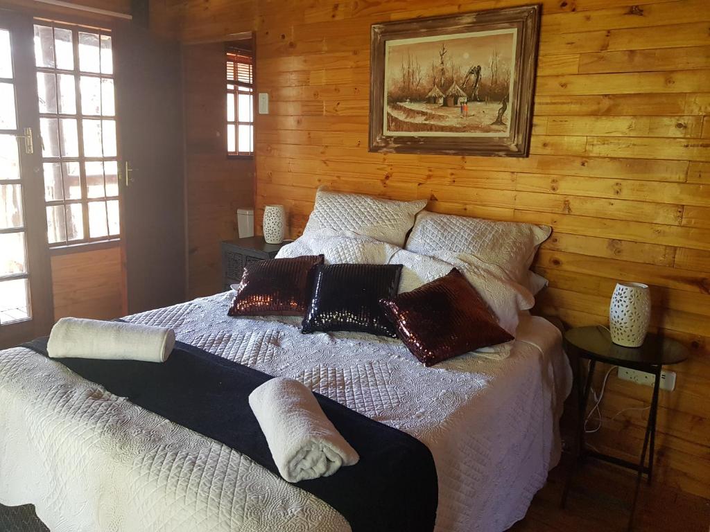 比勒陀利亚Cozy Wood Cabin的一间卧室配有带枕头的床