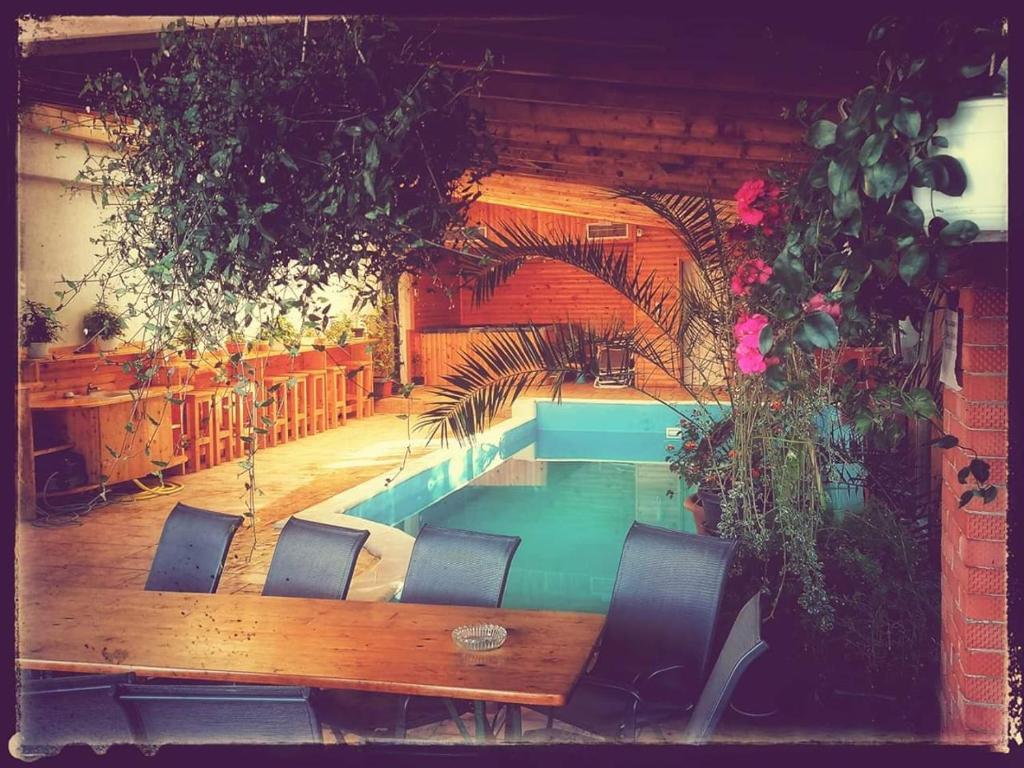 CîrceaDNT HOUSE & Spa的一个带椅子和桌子的房间的游泳池