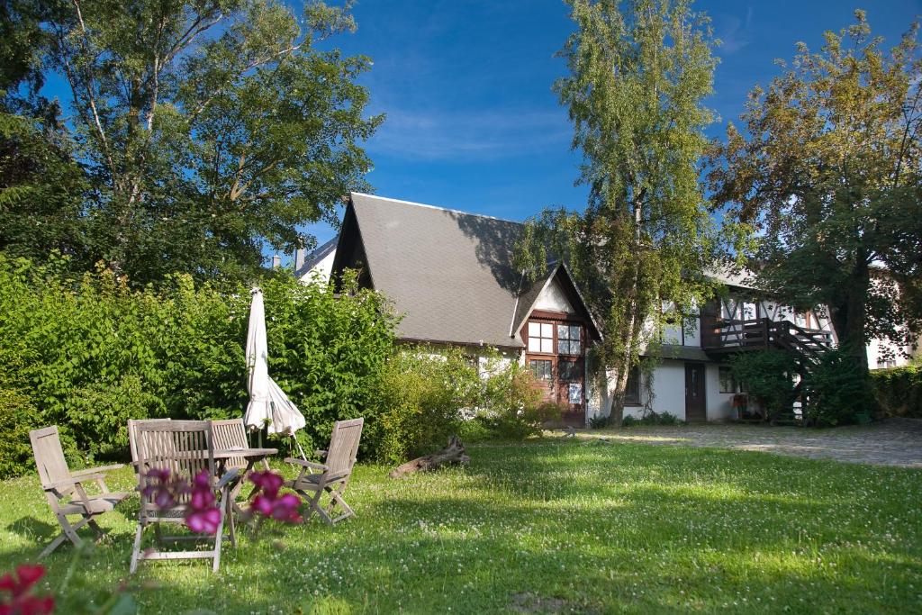 奥斯特巴德·哥伦Haus Mittagsruh-Göhren的房屋设有庭院、椅子和遮阳伞