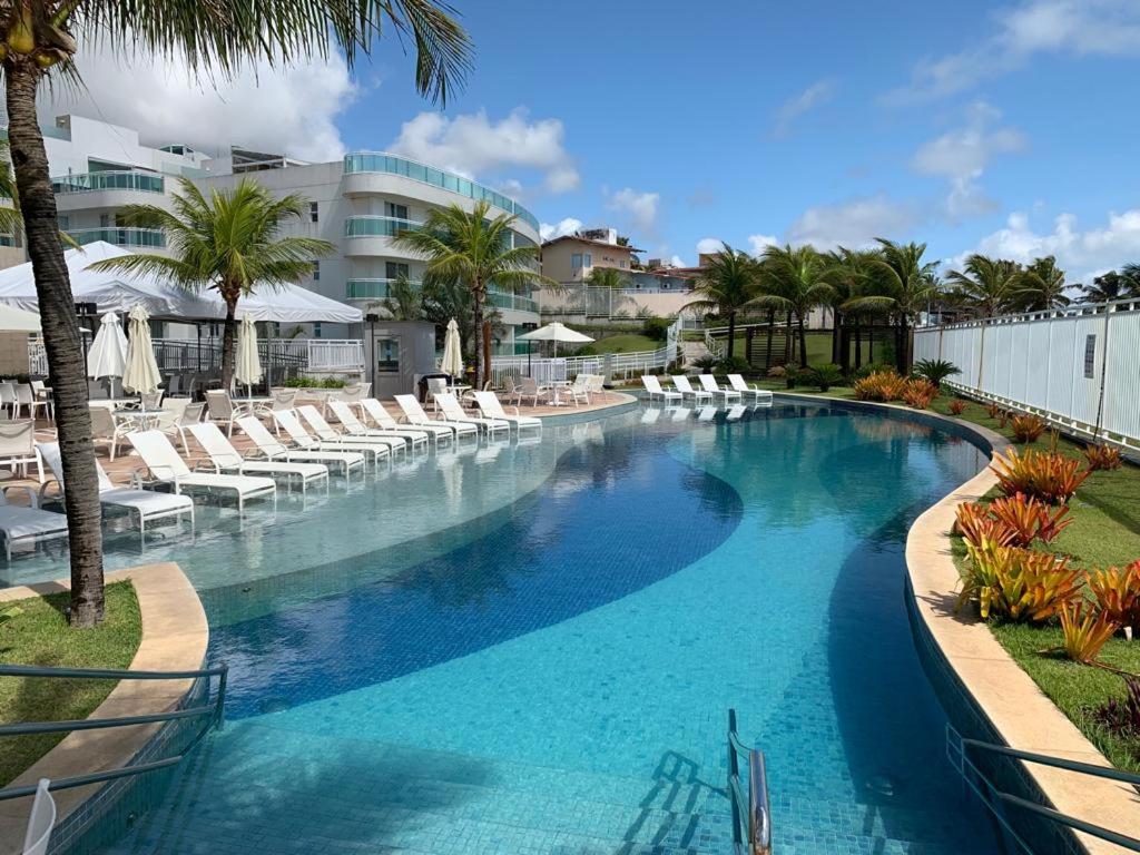 Granja Beira MarIn Mare Bali - Ala Muriu 332的一座带白色椅子和棕榈树的大型游泳池