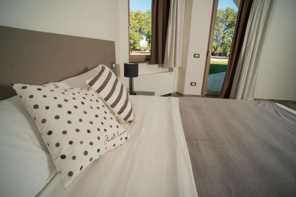 阿巴桑塔Regia Hotel的卧室配有带枕头的白色床和窗户。