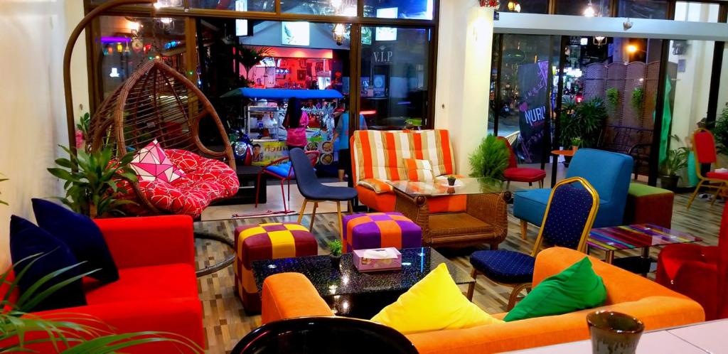 芭东海滩KANPAI HOTEL的一间商店里摆放着五颜六色的桌椅的房间
