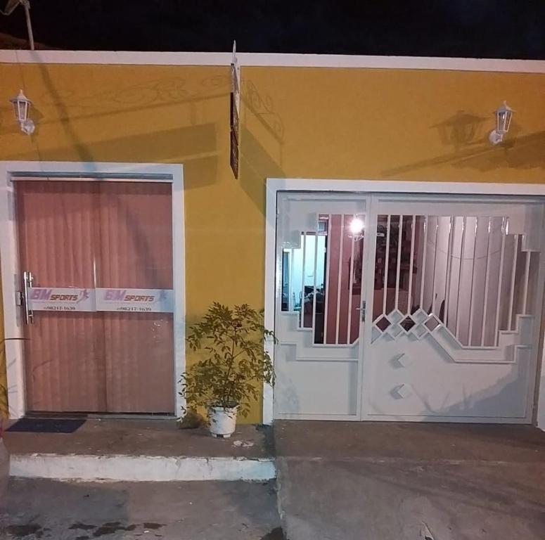穆库热Hospedaria Casa da Lia的门前有门和植物的房子