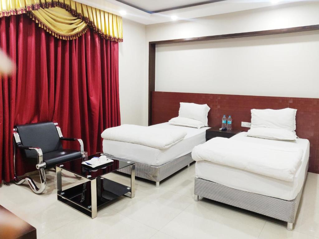 菩提伽耶Bodhgaya Seven Inn Hotel n Restaurant的酒店客房,配有两张床和椅子