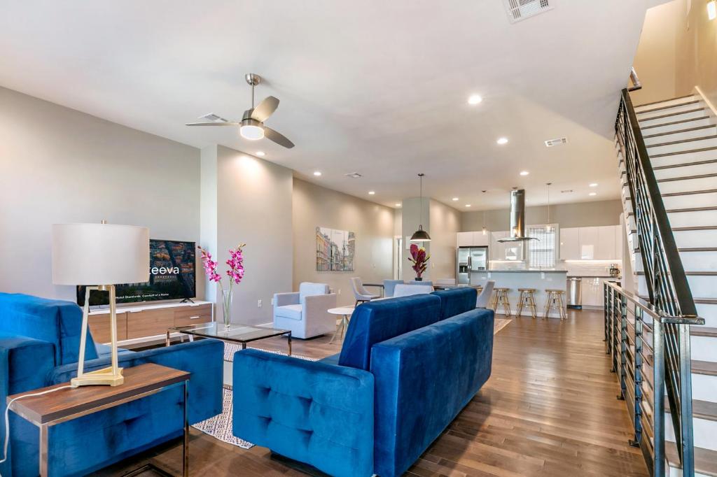 新奥尔良New Construction Elegant Villas的一间带蓝色家具的客厅和一间厨房