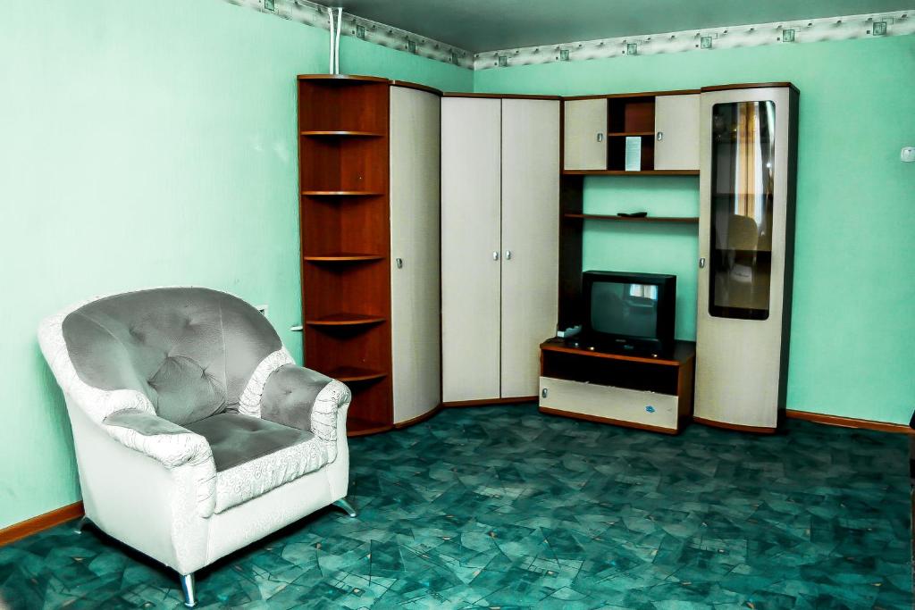 RakitnyyАпартаменты Кирова, 83的客厅配有椅子和电视