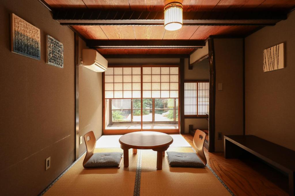 京都Yurakuan - Awagami Residence Inn的客房设有桌椅和窗户。