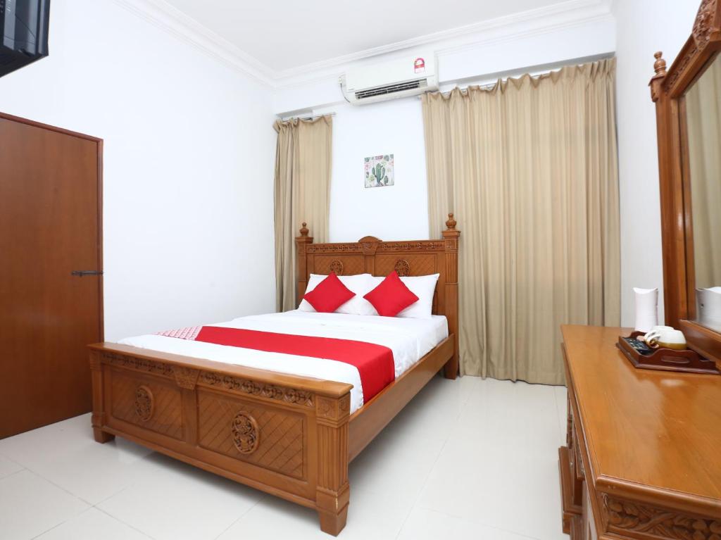 JertihSuper OYO 89435 Nusantara Group Hotel的一间卧室配有红色枕头的床