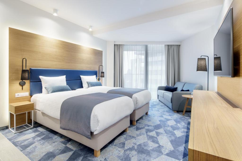 科沃布热格Seaside Park Hotel的酒店客房设有一张大床和一张沙发。