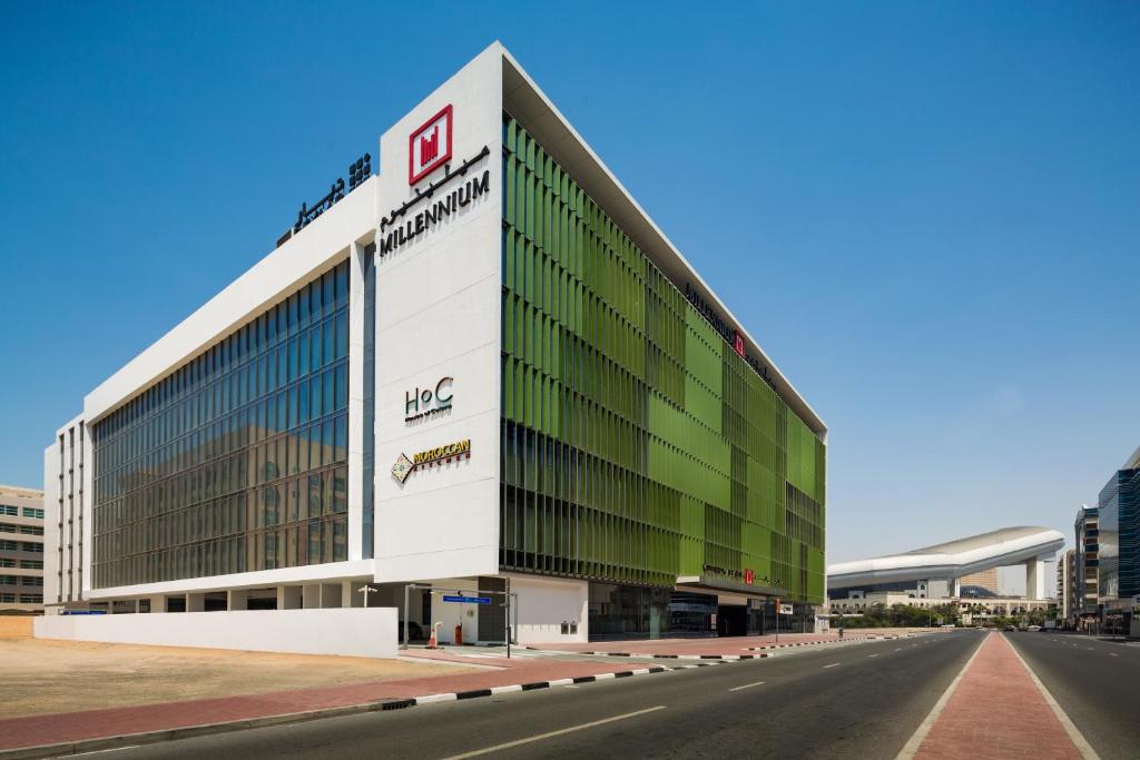 迪拜Millennium Al Barsha的一座拥有绿色和白色外墙的大型办公楼