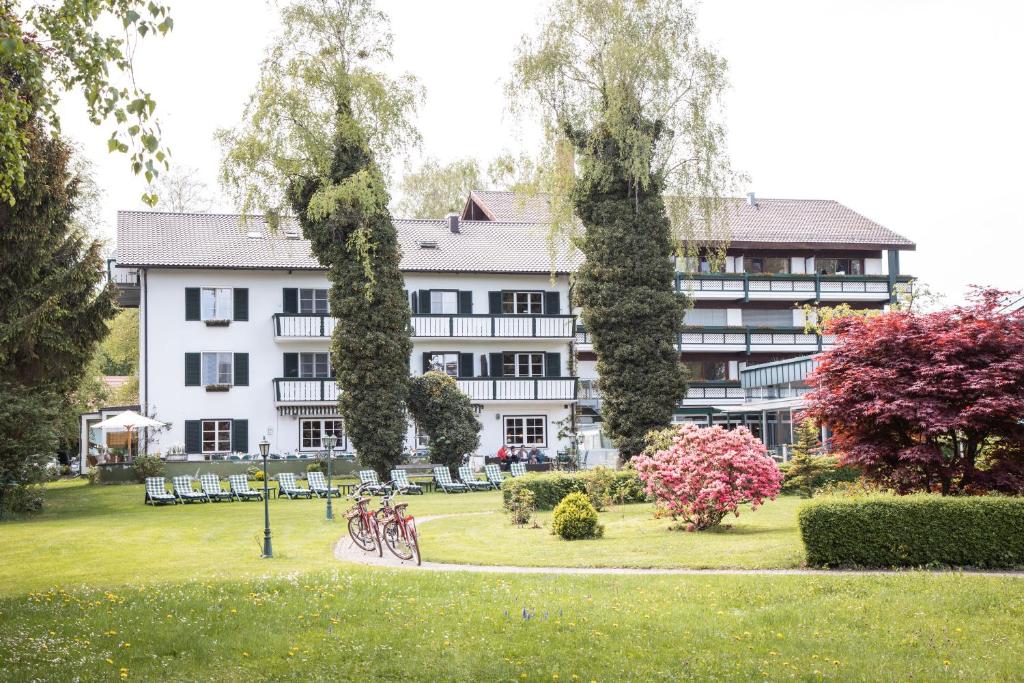 基姆湖畔普林莱因哈特花园酒店的一座白色的大建筑,自行车停在公园里