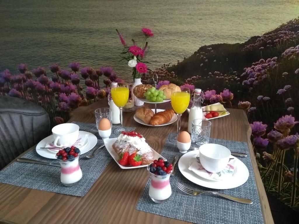 WestwoudBed & Breakfast Ons Nest的一张桌子,上面摆放着早餐食品、饮料和鲜花