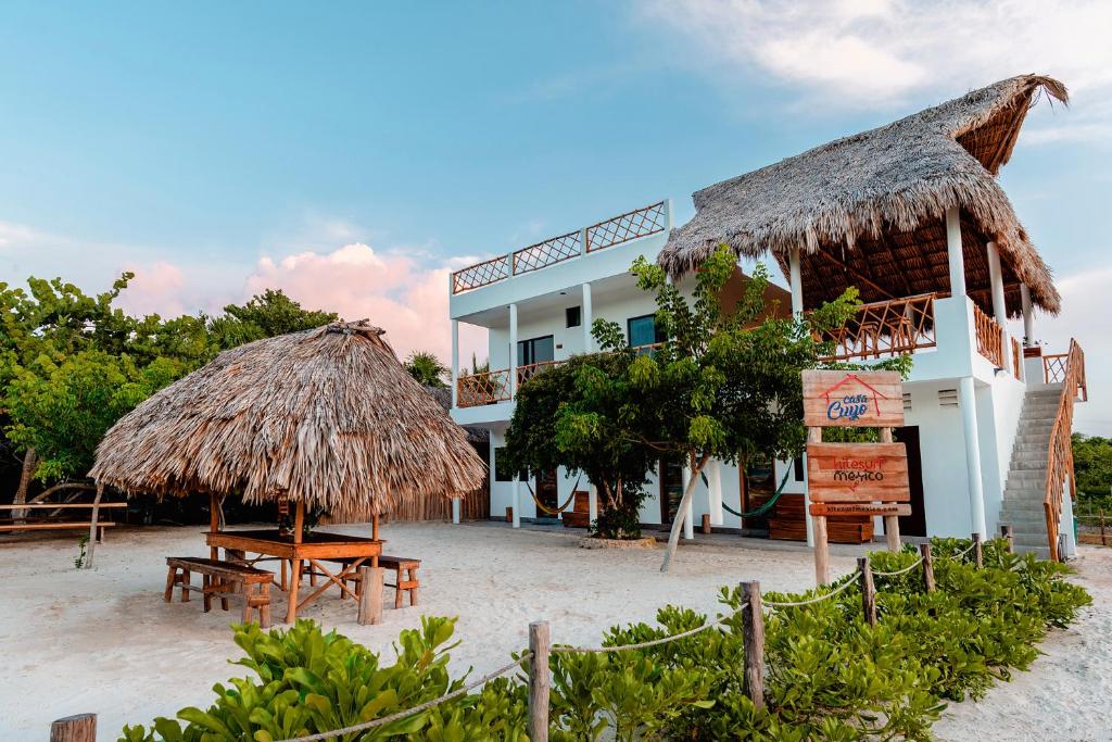 埃尔库约Casa Cuyo Hotel的海滩上拥有稻草屋顶的酒店
