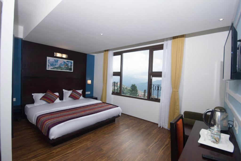 甘托克Bumblebee Bed & Breakfast的酒店客房设有一张床和一个大窗户