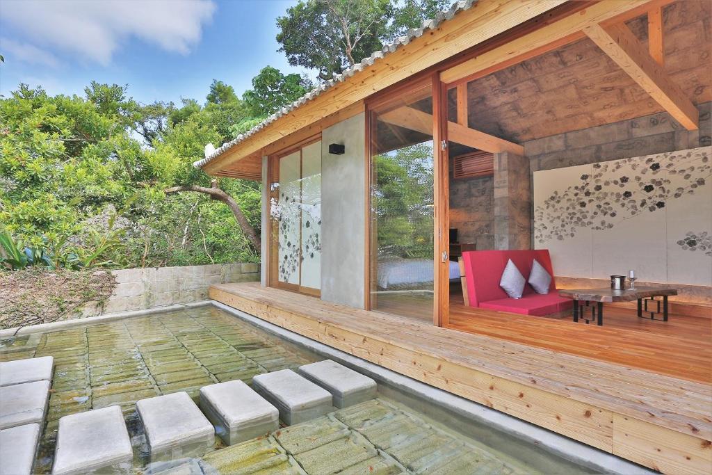 名户KAWASEMINOSU (MUKAKA VILLA)的户外庭院配有红色椅子和桌子