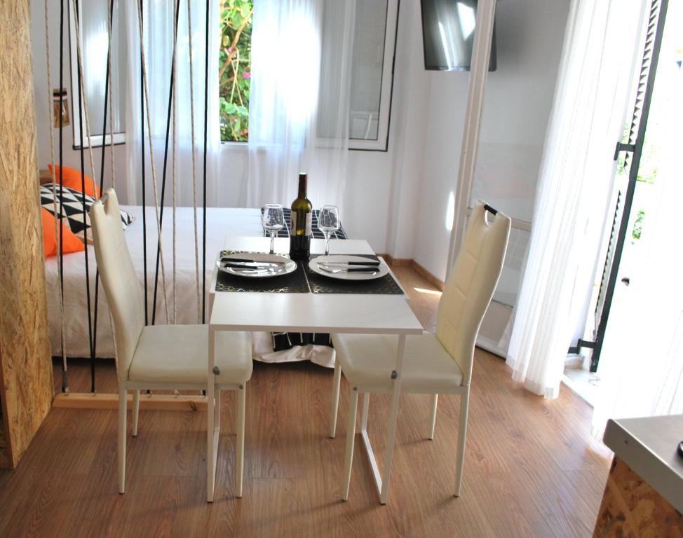 科孚镇Lilliput Studio Corfu Old Town的一间配备有白色桌椅的用餐室