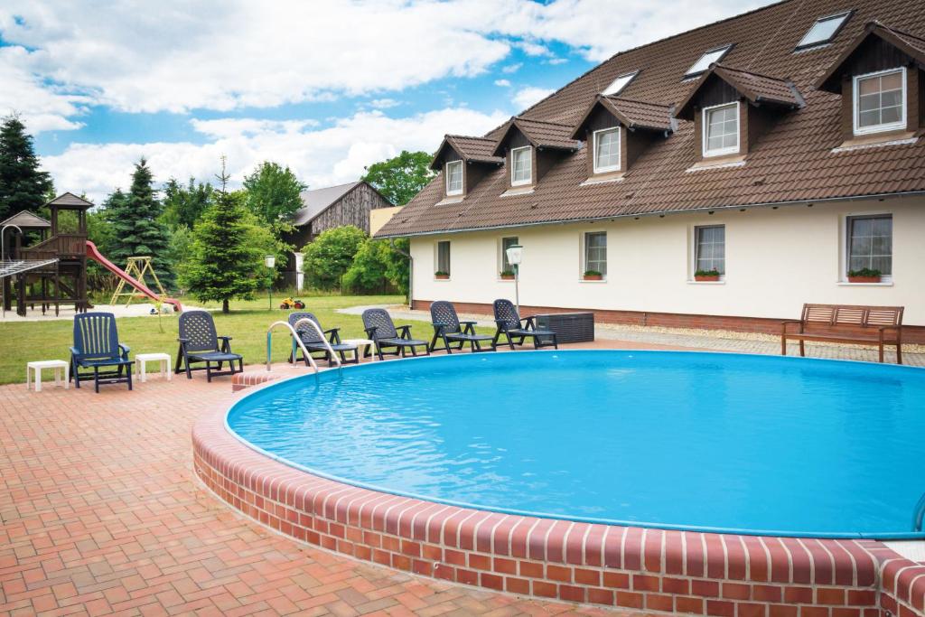 阔克威兹施普利瓦尔德假日酒店的一个带椅子的游泳池以及一座房子