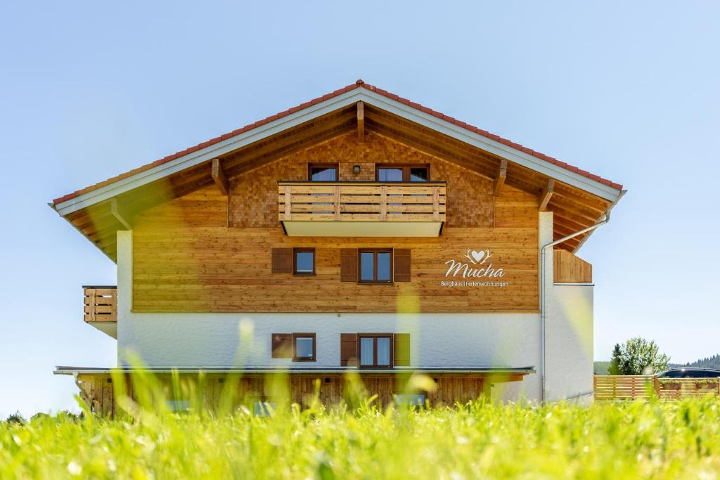 博尔斯特尔朗Berghaus Mucha - Ferienwohnungen - Naturpark Partner的草场上带阳台的木质建筑