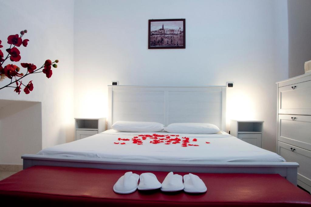 莫诺波利Mamma Maria 2010的一间卧室,床上有红色的鲜花