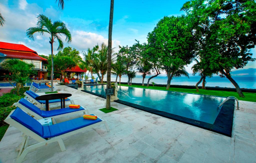 罗威那普瑞赛扬巴鲁玛海滩洛维纳酒店的一个带蓝色躺椅的游泳池和大海