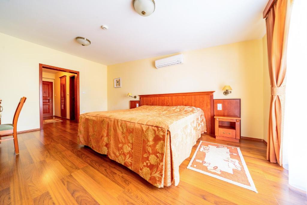 莫哈奇Pannon Hotel的一间卧室配有一张床,铺有木地板