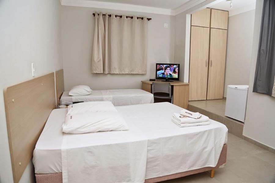 阿拉瓜里比格酒店的一间设有两张床和电视的房间