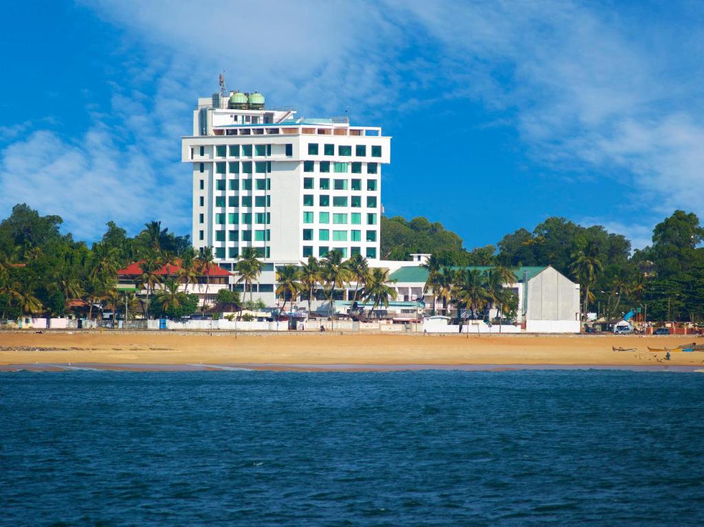 奎隆奎隆海滩酒店及会议中心的海滩上的白色建筑,带有海滩