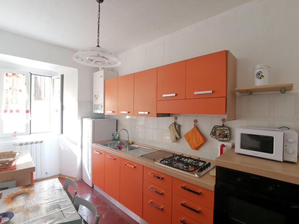 蓬特雷莫利Appartamento Liliana的一个带橙色橱柜和微波炉的厨房