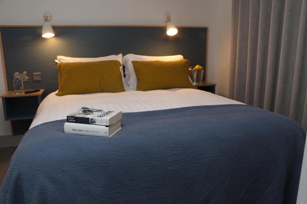 海上费萨德Baginbun Lodge的一间卧室配有一张床,上面有两本书