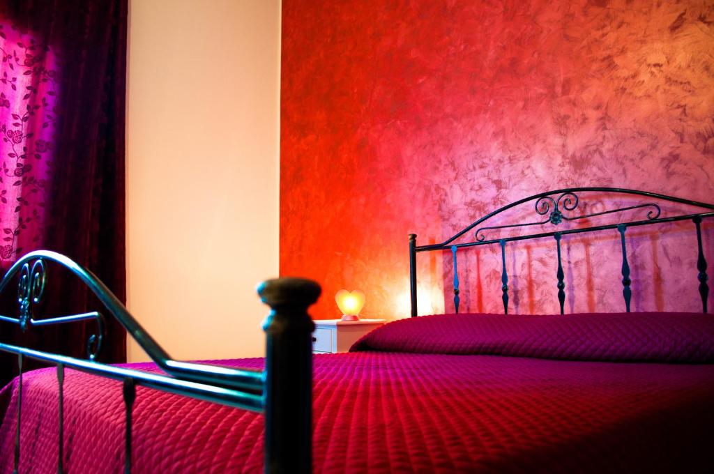 马尔萨拉利伯塔玛萨拉住宿加早餐旅馆的一间卧室设有一张床和红色的墙壁
