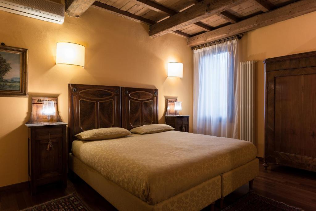 费拉拉Piazza Nova Guest House的一间卧室配有一张床、两盏灯和一个窗户。
