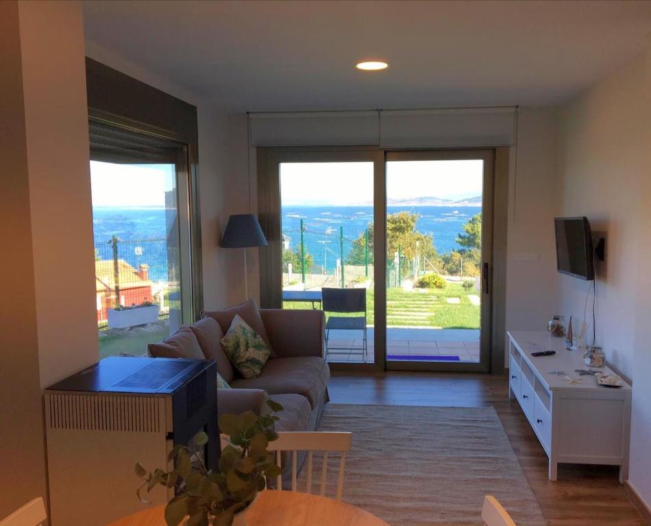 希奥Casa apartamento a pie de playa Areabrava - en Cangas - Hio -Galicia- España的客厅配有沙发和带电视的桌子