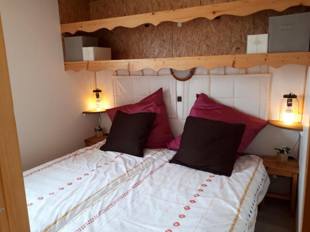 Saint-Offenge-DessousAux Paniers Coussins HOMALYS的一间卧室配有一张带红色枕头的大床