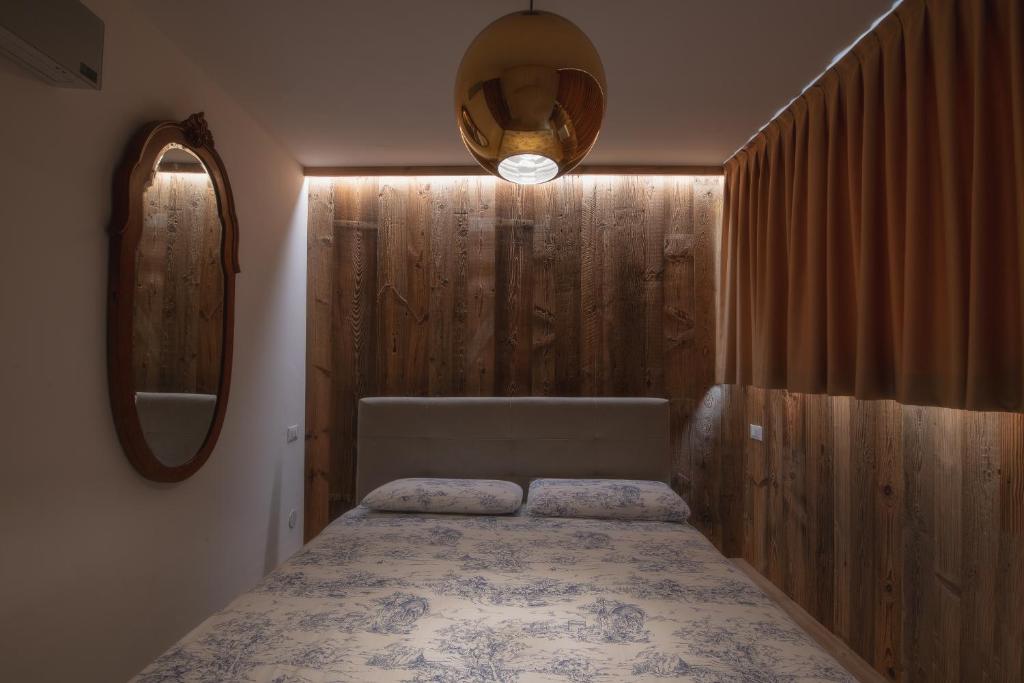 摩德纳迪-坎皮格里奥Chalet Golf Campiglio / LuxApt / fronte piste-impianti-golf的一间卧室配有一张床和镜子