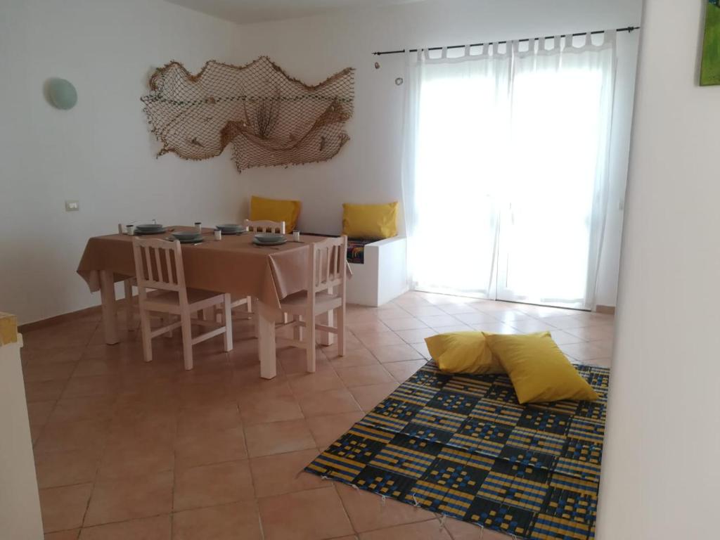萨尔雷Apartments Mistral Estoril Beach的一间带桌子和黄色椅子的用餐室