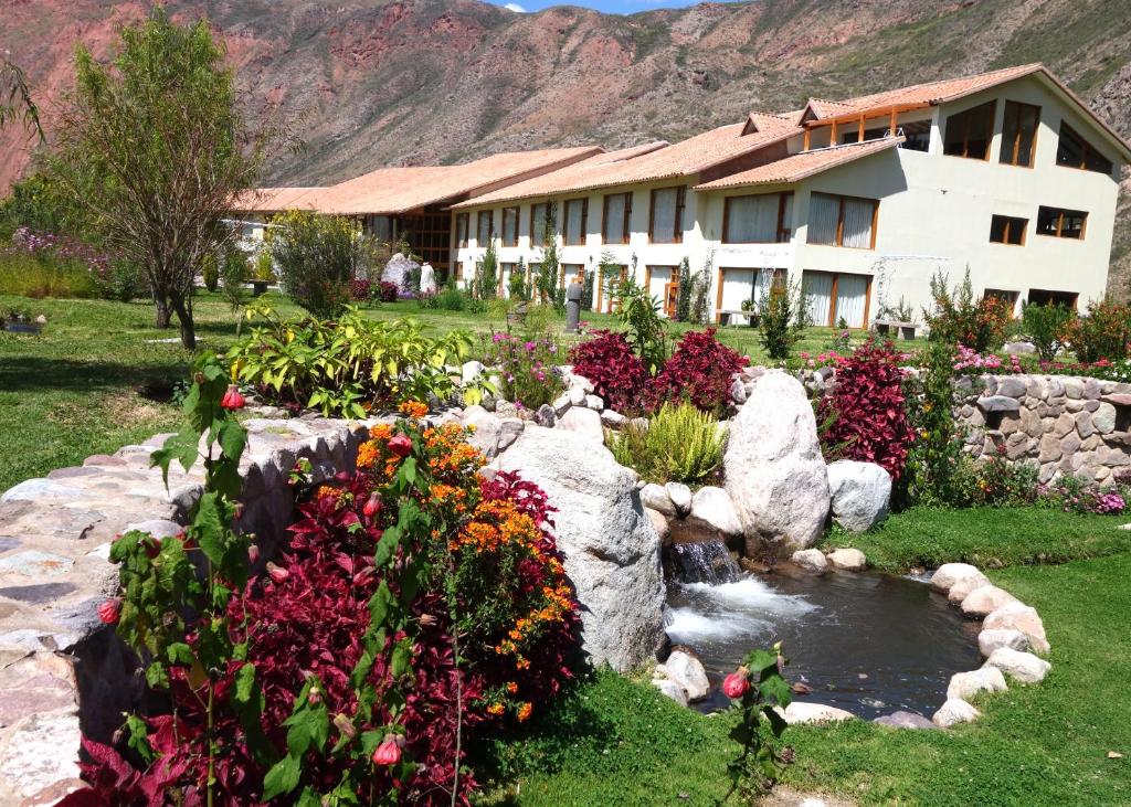 乌鲁班巴巴列萨格拉多塔皮卡拉豪华酒店的一座花朵的建筑,前面有一个池塘