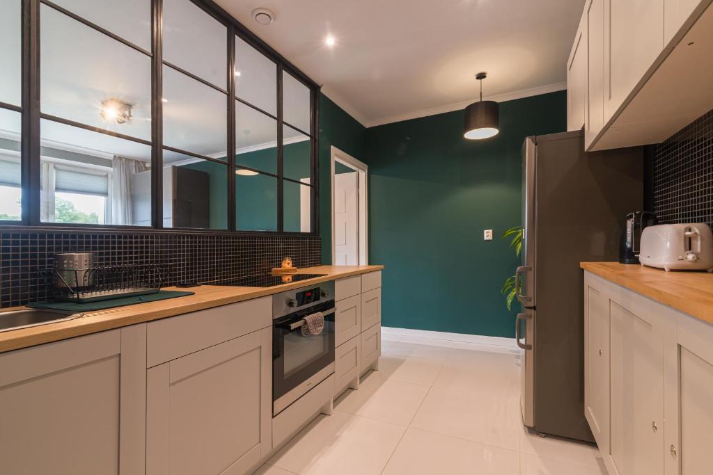格但斯克Main Street Studio的厨房配有白色橱柜和绿色墙壁