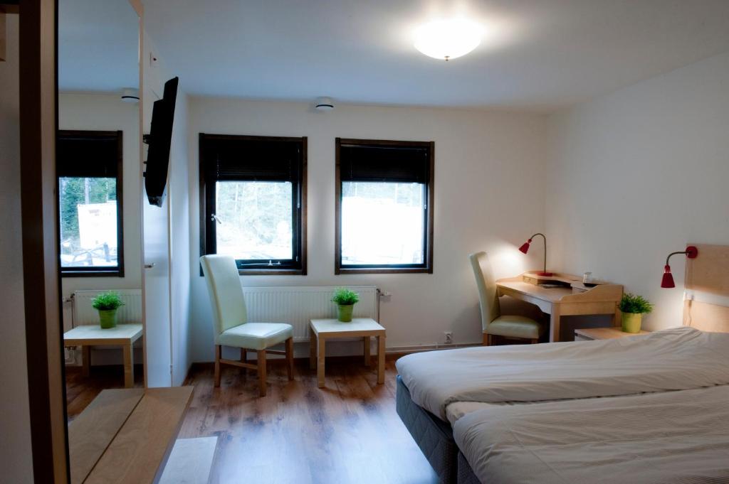 图什比STF Valbergsängen Sporthotell的卧室配有一张床和一张桌子及椅子