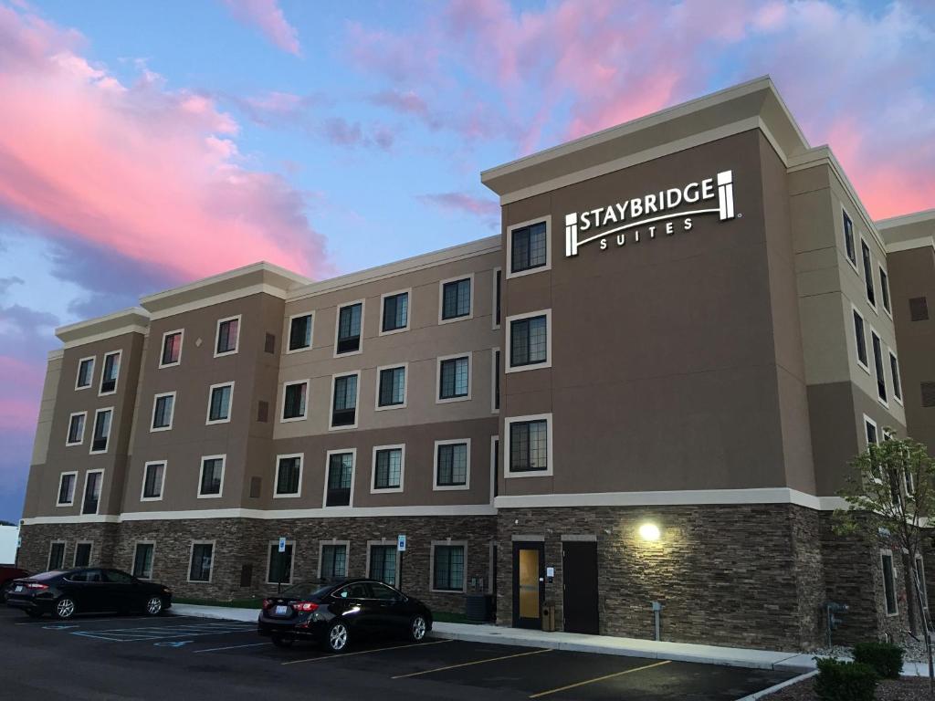 安娜堡Staybridge Suites Ann Arbor - Research Parkway, an IHG Hotel的使馆酒店在停车场停车的 ⁇ 染