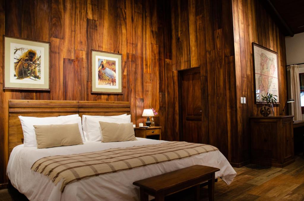 ConcepciónEl Tránsito Hotel Boutique的一间卧室配有一张带木墙的大床
