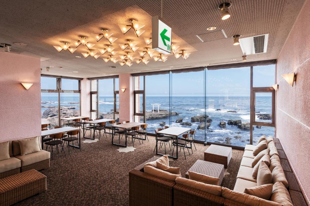大洗町Oarai Hotel Annex Gyoraian的一间带桌椅的海景餐厅