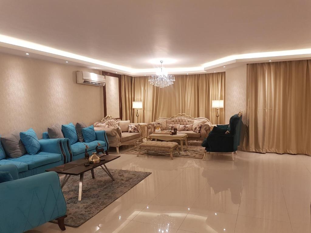 开罗Lebanon Apartment的大型客厅配有蓝色的沙发和椅子