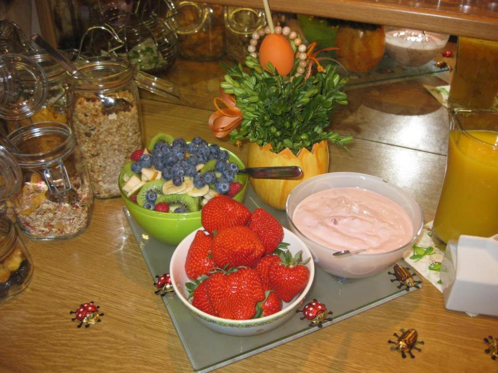 哈格瑙Gästehaus Ainser的桌子上放着一碗水果,然后浸泡