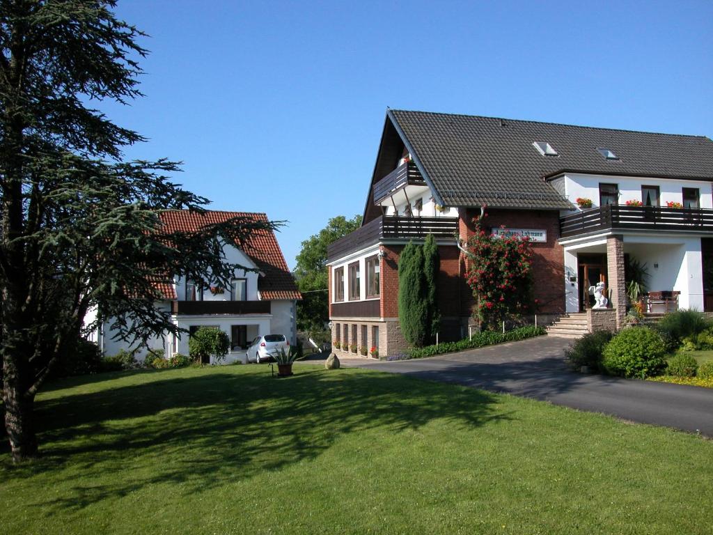 Bad Eilsen兰德豪斯拉曼酒店的前面有绿色草坪的大房子