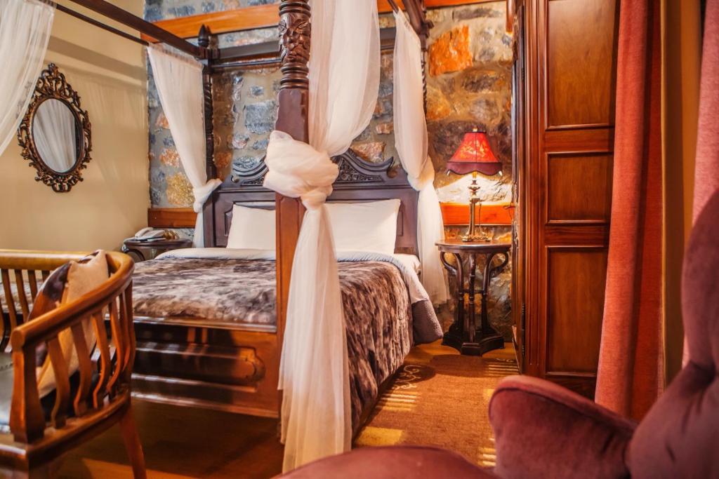 帕雷斯阿吉萨那Montecristo Chalet的一间卧室配有一张天蓬床和一把椅子