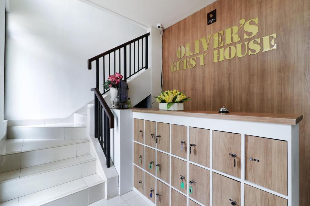 当格浪Oliver's Guest House的楼梯,有木柜和第一个房子的标志