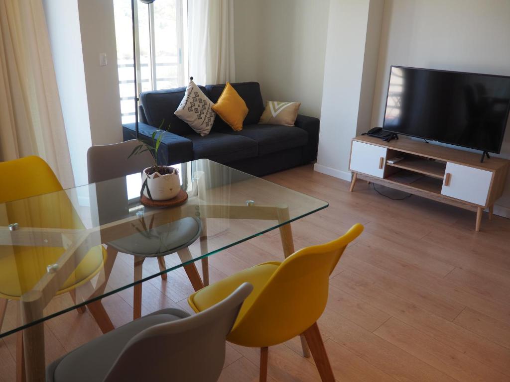 艾因萨Apartamento Vive Ainsa的客厅配有玻璃桌和黄色椅子