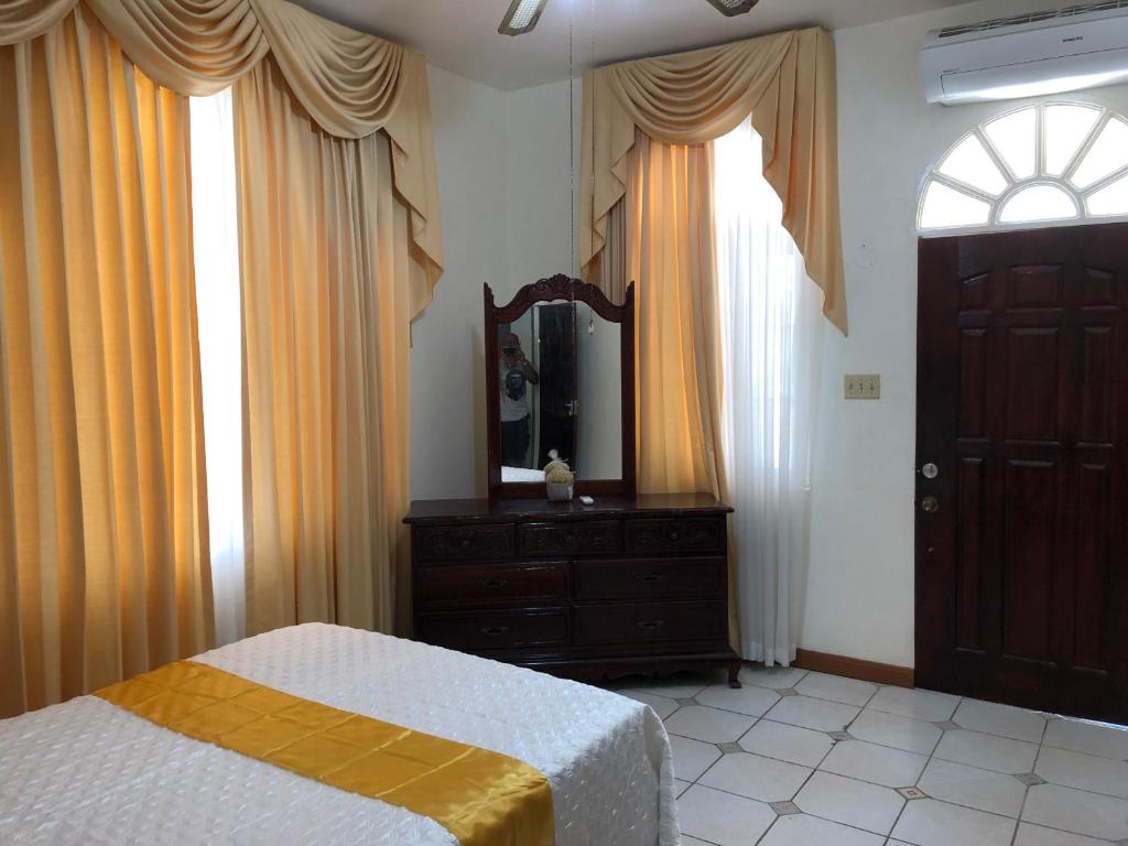 欧丘里欧GoldenView Guesthouse Ocho Rios的一间卧室配有一张床、梳妆台和镜子